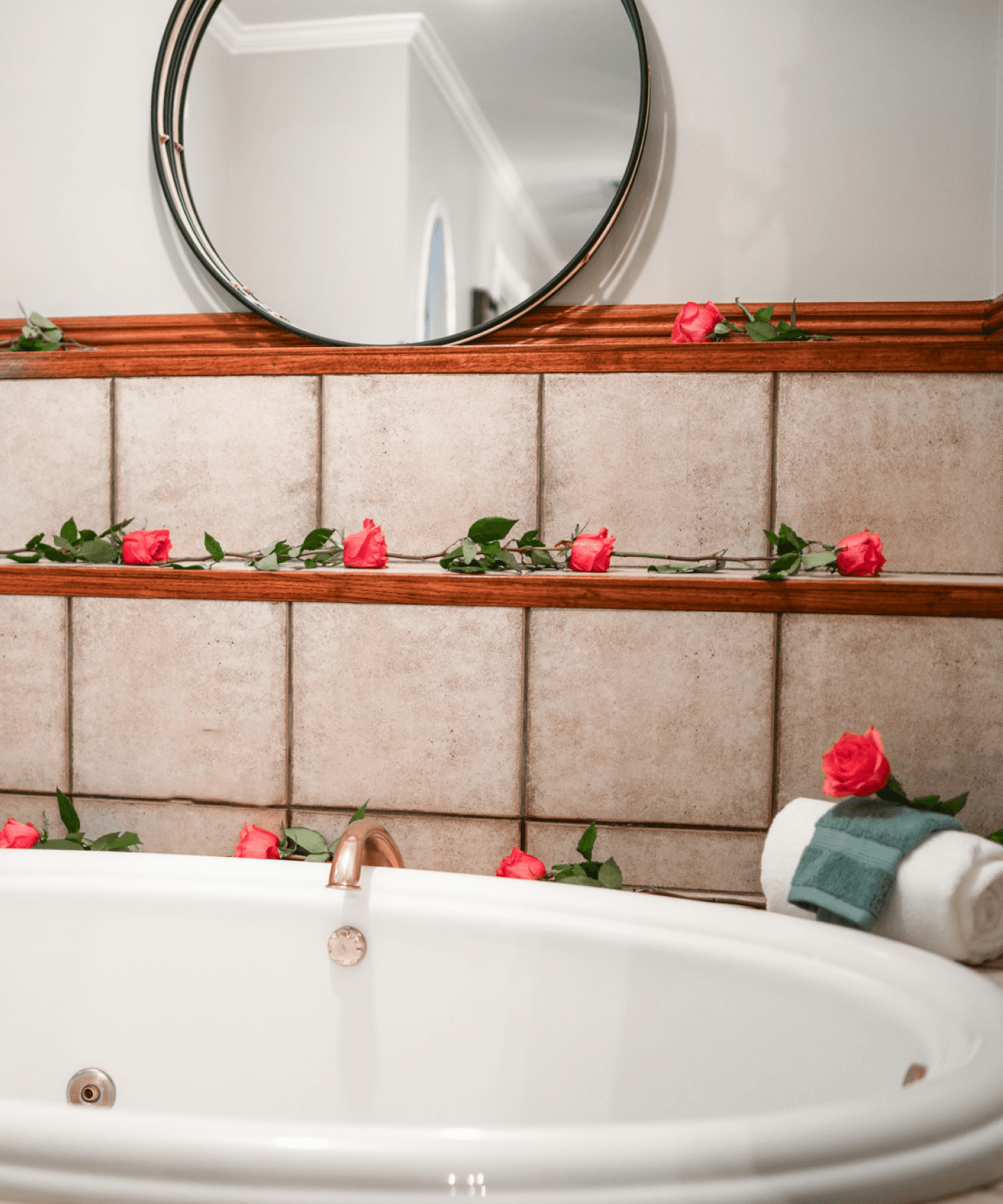 Fresh roses laid along the tiled ledge of an in-room Jacuzzi