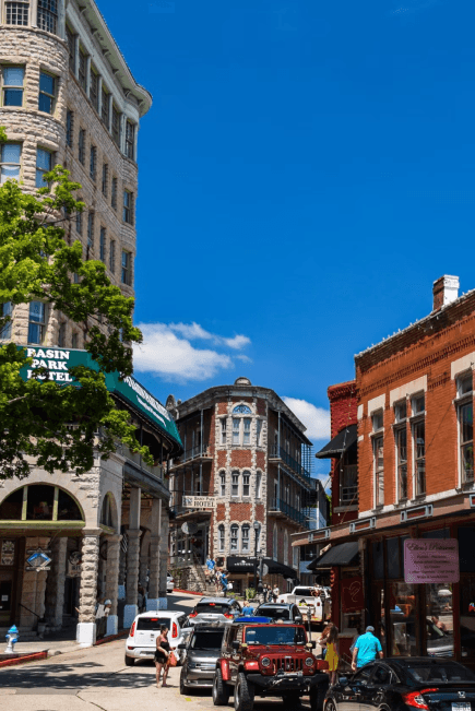 Basin Park Hotel and brick storefronts on a sunny street in downtown Eureka Springs