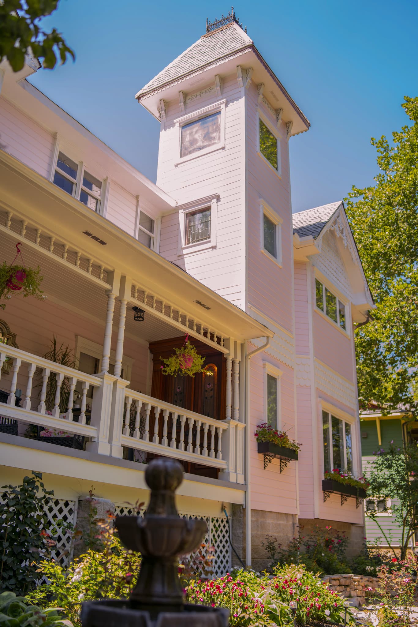 The pink Victorian tower and front porch of Inn at Rose Hall on a sunny day
