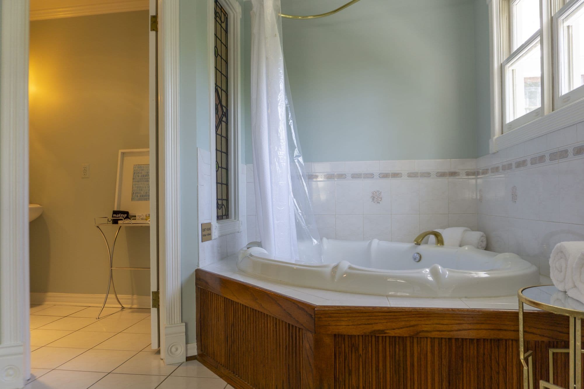 Corner Jacuzzi with a brass shower rail in the Hemingway Suite